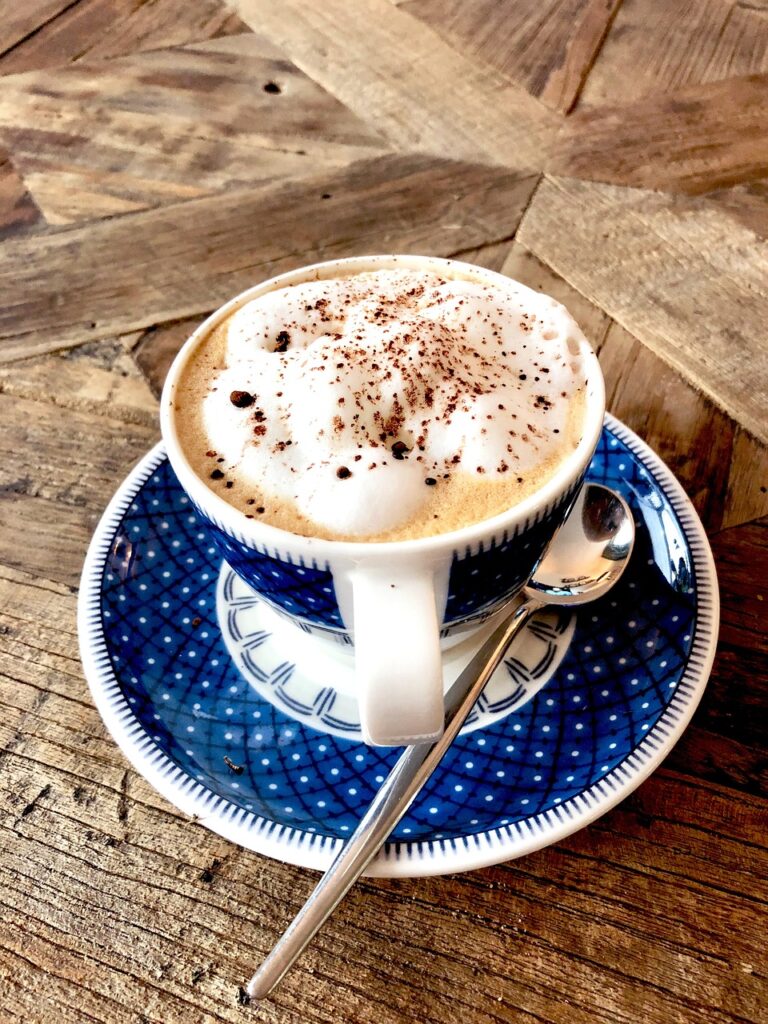 eine Cafetasse steht auf einem Holztisch, wunderbar appetitlich